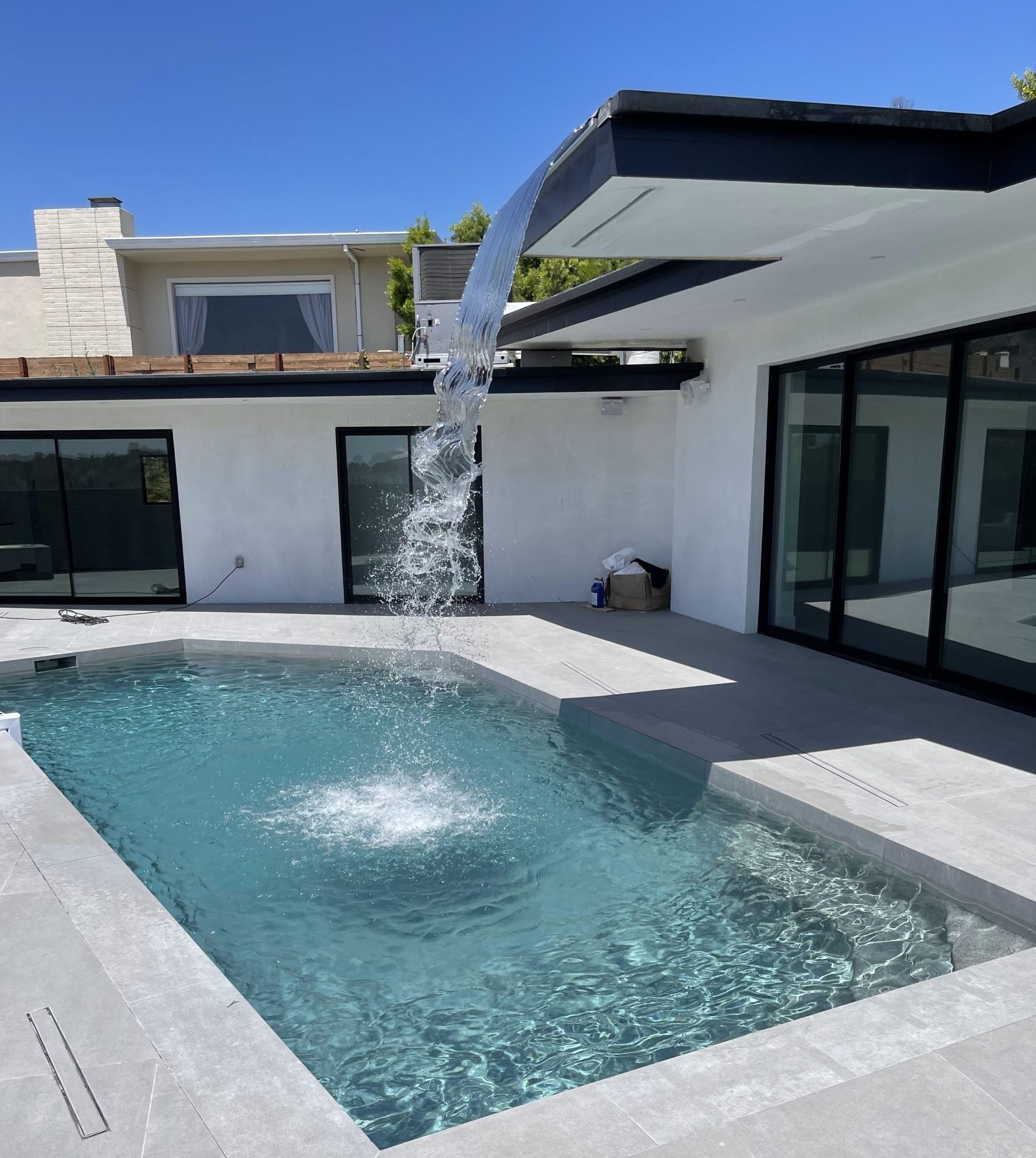 Custom waterfall flowing from the roof into a pool