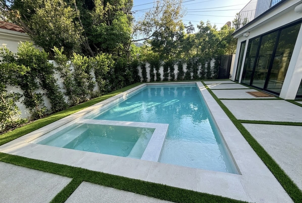 Modern pool construction with white precast concrete coping, large-format pavers and artificial grass